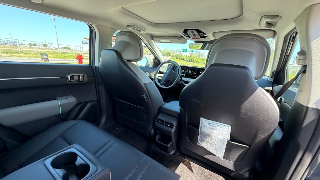 Habitacle de la Kia EV4 Wind Premium 2026 vu de la banquette arrière en similicuir, sous le toit ouvrant